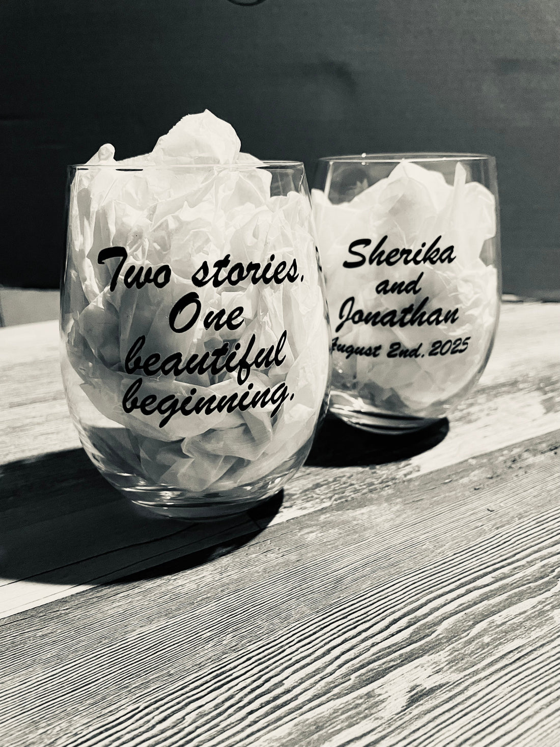 Two stemless wine glasses glass with custom design for an anniversary celebration.