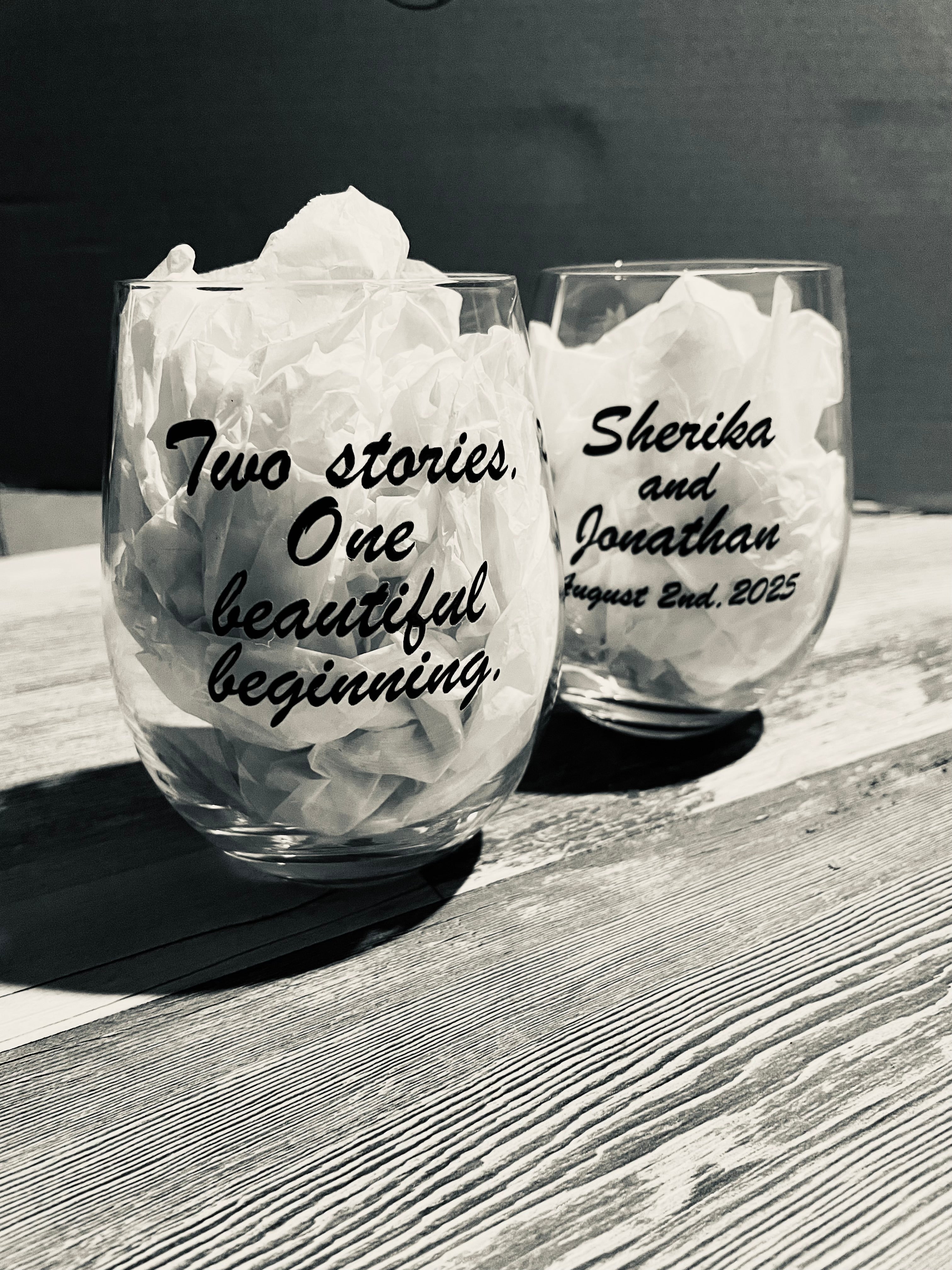 Two stemless wine glasses glass with custom design for an anniversary celebration.